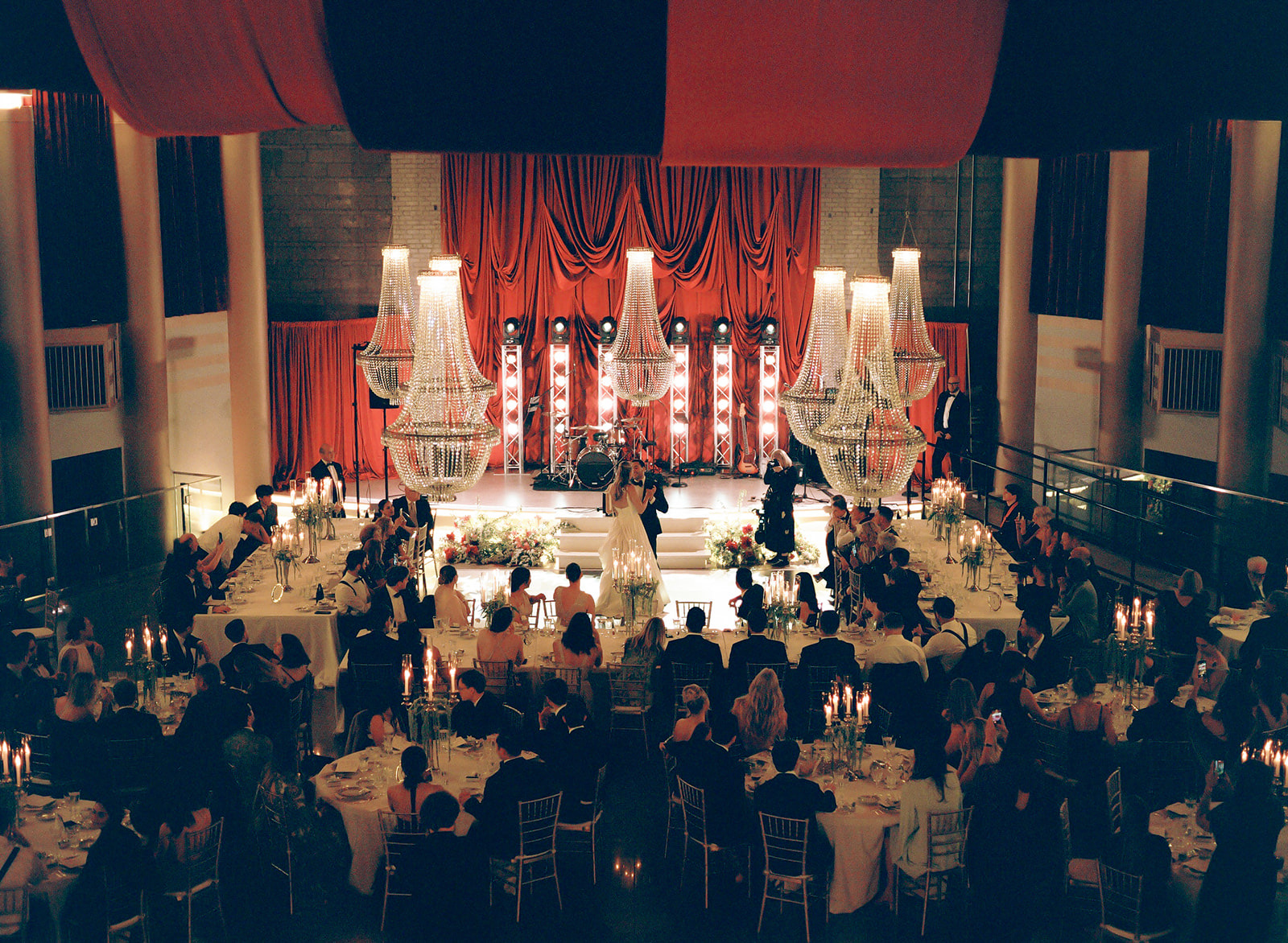 The Hollywood Theater ballroom from above, chandeliers over candlelit tables and the couple dancing center stage, shot on film