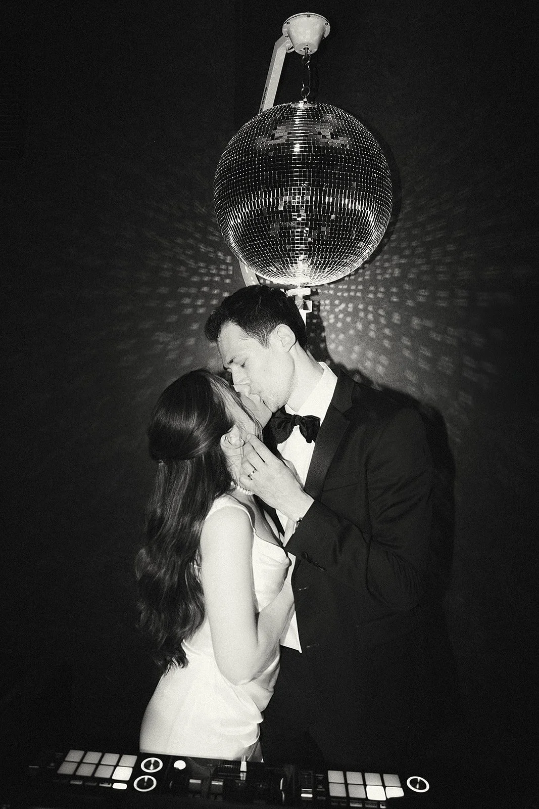 Rachel and Collin kissing beneath a disco ball, in black and white