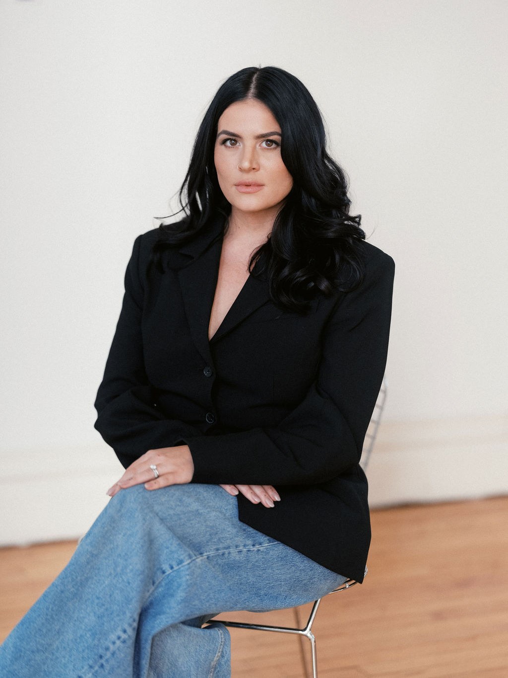 Steph Koehne seated in the studio in a black blazer, smiling